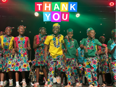 Wide shot of the Singing Children of Kenya performing, smiling, or singing in Portishead
