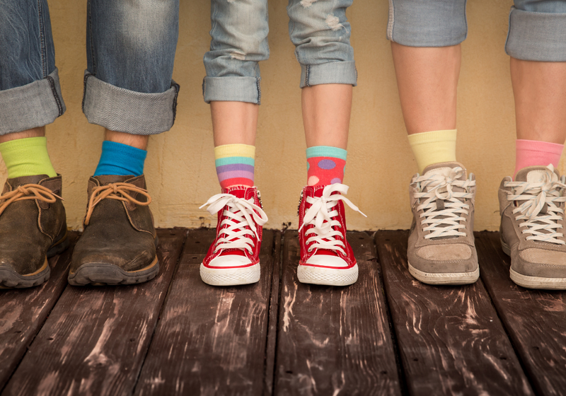 An image of three children lined up showing their shoes